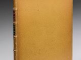 un vieux livre avec une couverture dorée sur fond noir