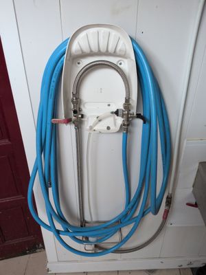 a white toilet with blue hoses attached to it