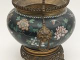 a large vase with a bird on it sitting on a stand