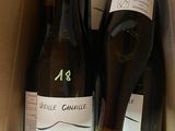 three bottles of wine in a box with labels on them