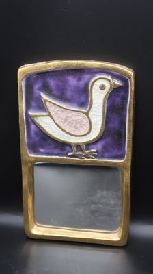 a close up of a small mirror with a bird on it
