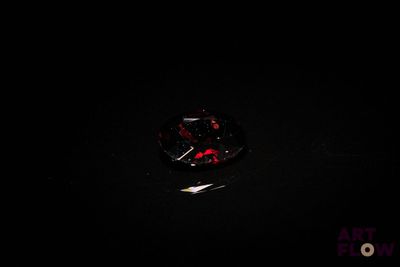 un gros plan sur un diamant rouge et noir dans l'obscurité