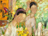 two women sitting at a table with flowers in front of them