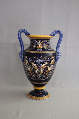 un vase bleu et jaune posé sur une surface blanche