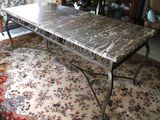 a table with a marble top on a rug in a living room