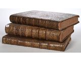 three old books stacked on top of each other on a table