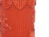 a red vase that has a design on it