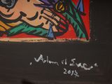 graffiti on the wall of a bathroom with a toilet and a painting on the wall