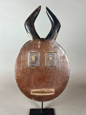 une image représentant une sculpture en bois représentant un visage orné de cornes