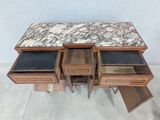 a marble top table with three drawers on it