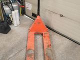 a forklift sitting in a garage next to a garage door