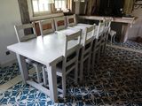 une table et des chaises blanches au milieu d'une pièce