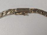 a close up of a silver bracelet on a white surface