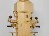 a golden coffee machine that is sitting on a table