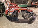 a tractor with a plow attached to it in a barn