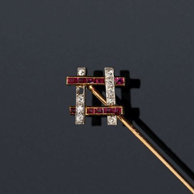 un gros plan d'une broche en diamant et rubis fixée sur une tige