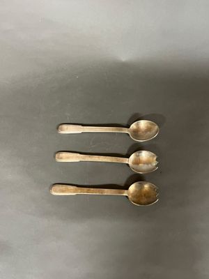 trois cuillères en argent posées les unes à côté des autres sur une table