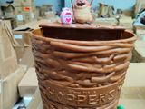 a large brown pot with a toy on top of it