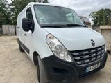 La camionnette blanche est garée sur la terre battue du parking.