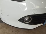 a white car that has been dented and is parked in a garage