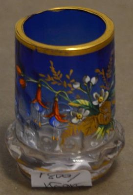 un vase bleu bordé d'or et orné de fleurs