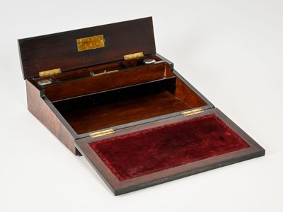 une boîte en bois doublée de velours rouge