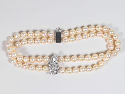 un gros plan sur un collier de perles blanches muni d'un fermoir en argent