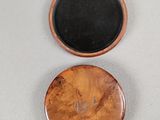 a small wooden box with a black lid on a white surface