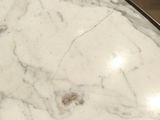 a close up of a marble table top with a clock on it