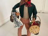figurine of a man with a basket of fruit and a bag of bread