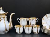 un service à thé blanc et or avec tasses et soucoupes