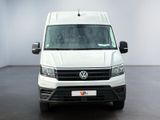 the white van is parked in a large room with a black floor