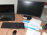 a desk with a laptop, monitor, keyboard and cell phone on it