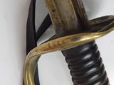 a close up of a sword on a white surface