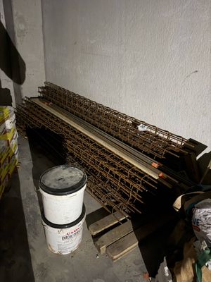 un tas de bois et un seau de peinture dans une pièce