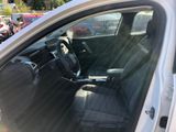 the interior of a car with the door open and the driver ' s seat down