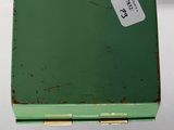an old green box with a price tag on it sitting on a white surface
