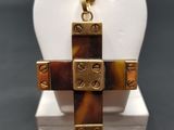 a close up of a cross pendant on a display stand