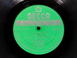 an old record with a green label on it sitting on top of a table