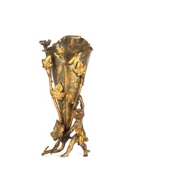 un vase en or posé sur une surface blanche