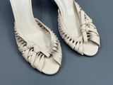 une paire de chaussures pour femme avec des talons à volants sur un fond gris