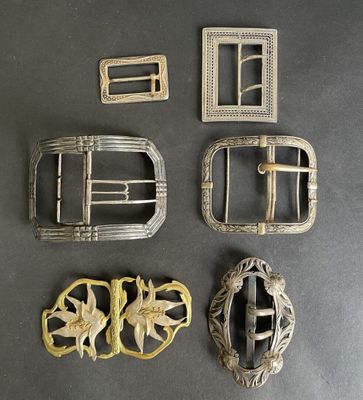 four antique belt buckles and a belt buckle with a flower design