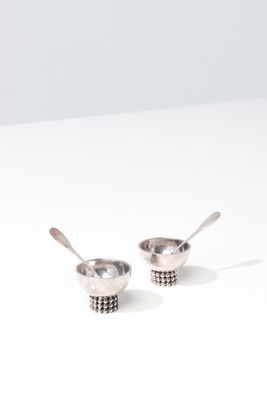 two spoons are sitting on top of each other on a table