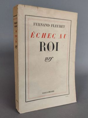 un vieux livre posé sur une table à côté d'un mur gris
