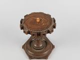 wooden pedestal with a candle on top of it on a white surface