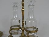 two glass bottles and a brass holder on the table