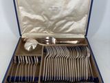 a set of silverware in a blue case on a white surface