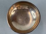 a silver bowl on a table with a white background