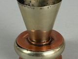 a silver cup on top of a copper plate