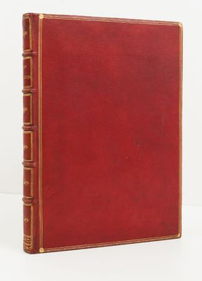 un vieux livre rouge posé sur une table blanche